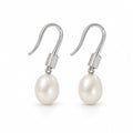 Adriana pearl earrings, 7-8mm white rice pearls beneath ribbed shepherd's hooks and caps - second finish