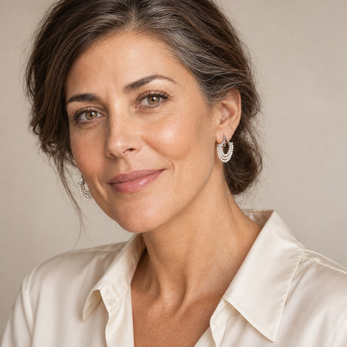 Woman in her thirties wearing the Aimee seed pearl swag huggie earrings, hair down