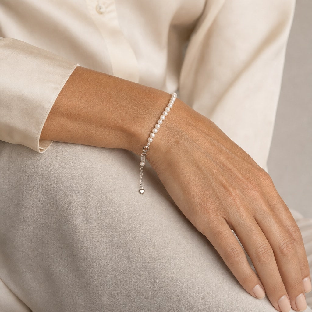 Close-up of a hand and wrist wearing the Alexandra white pearl strand bracelet with the extender chain hanging