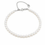 Alexandra classic single-strand white freshwater pearl bracelet with silver clasp and heart charm, flat lay on beige