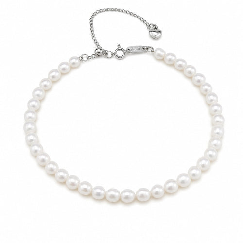 Alexandra classic single-strand white freshwater pearl bracelet with silver clasp and heart charm, flat lay on beige