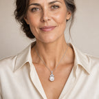 Woman wearing the Astrid crystal cluster pearl pendant necklace at the sternum with a black boat-neck top