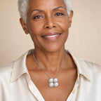 Woman wearing the Birgitta four-pearl pendant necklace at the sternum with a black boat-neck top