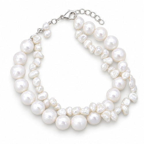 Clara double-strand white freshwater pearl bracelet with a round strand and a keshi strand on a blue resin slab