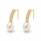 Clemence pearl earrings, 7-8mm white rice pearls fixed beneath curved pavé bars
