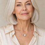 Woman wearing the Dagny leaf sprig pearl necklace at the collarbone with a natural linen shirt