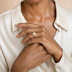 Close-up of a model's hand wearing the Delia quilted disc pearl ring in gold