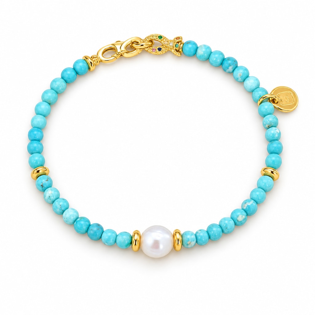 Dorotea turquoise-blue bead bracelet with a single white freshwater pearl and polished clasp section, flat lay on pale green
