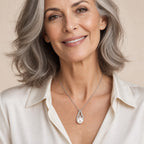 Woman wearing the Edith pavé teardrop pearl pendant necklace at the sternum over a black ribbed top