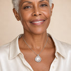 Woman wearing the Emmeline knot halo pearl pendant necklace at the sternum over a black ribbed top