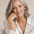 Close-up of a wrist wearing the Eugenia white pearl bracelet with red accent bead