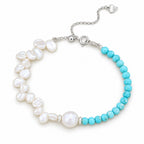 Flavia half-and-half bracelet of white keshi pearls and turquoise-blue beads with a round focal pearl, flat lay on cream