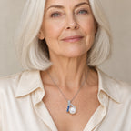 Woman wearing the Greta blue ombré bar pearl pendant necklace at the sternum with a navy crew-neck top