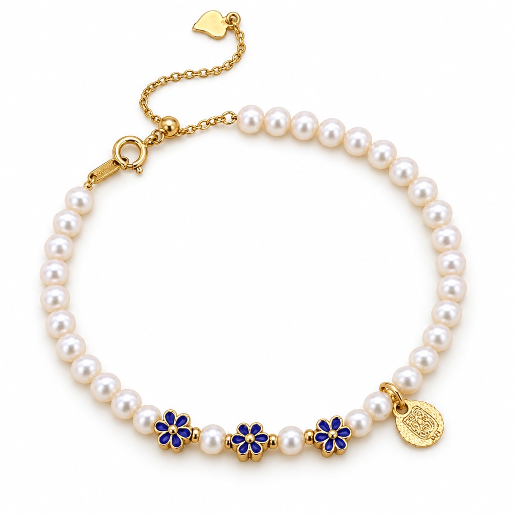 Ilaria white freshwater pearl bracelet with three blue enamel flower beads and a round medallion charm, flat lay on cream