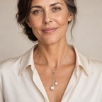 Woman wearing the Ingrid double pearl lariat necklace falling to the sternum with a black V-neck dress