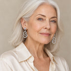 Woman in her sixties wearing the Jolien grey pearl gourd drop earrings, hair half up