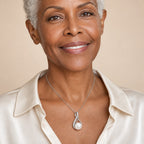 Woman wearing the Karin twist loop pearl pendant necklace at the sternum with a black boat-neck top