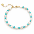 Letizia bracelet of white rice pearls alternating with turquoise-blue beads, flat lay on cream