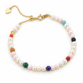 Ludovica white freshwater pearl bracelet with scattered multicolor beads, flat lay on cream