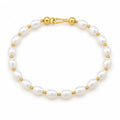 Maddalena bracelet of white rice pearls alternating with small polished metal beads, on a cream velvet tray