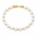 Maddalena bracelet of white rice pearls alternating with small polished metal beads, on a cream velvet tray