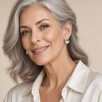 Woman in her sixties wearing the Mathilde ribbon loop pearl studs, hair pinned half up