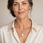 Woman wearing the Maude pavé cone cap pearl pendant necklace at the sternum with a black crew-neck top