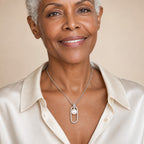 Woman wearing the Ruth pavé oblong frame pearl pendant necklace at the sternum with a black crew-neck tee
