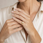 Close-up of a model's hand wearing the Sheila square frame pearl ring in gold