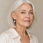 Woman in her fifties wearing the Tove rice pearl lever-back earrings, hair down